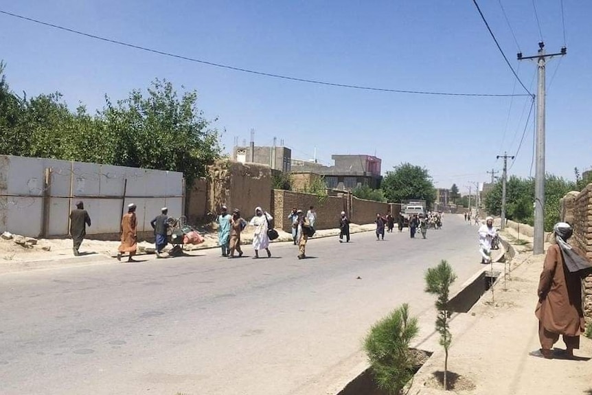 Taliban fighters mill around on a street after being freed from prison in Sheberghan