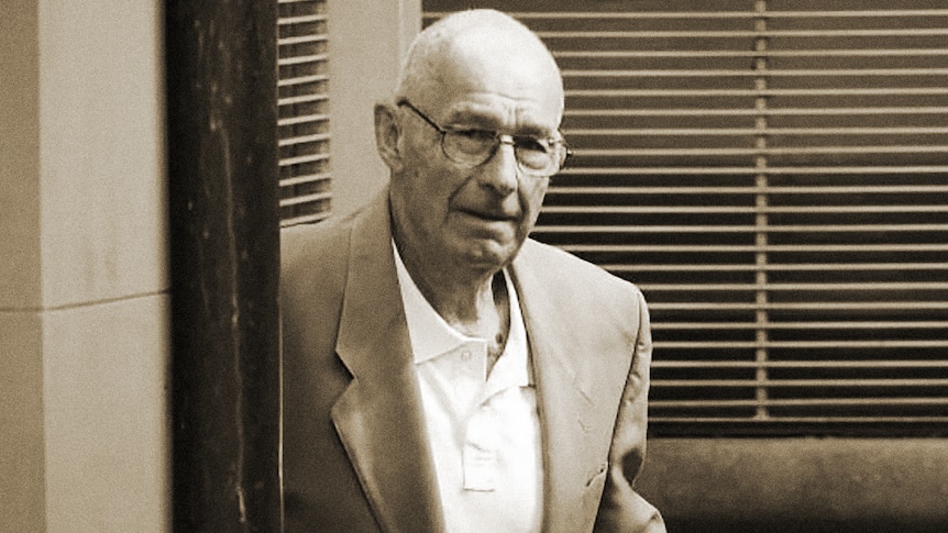 Roger Rogerson, a man wearing glasses, blazer and shirt leaves a building