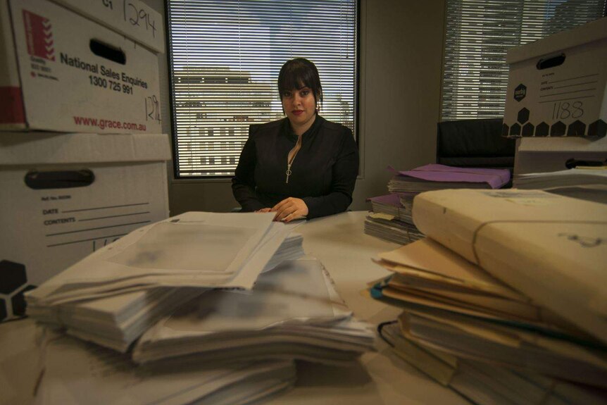 Dassi Erlich with paperwork