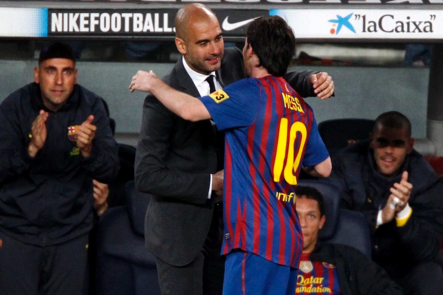 The Barcelona manager leans in to hug his star player on the sidelines during a La Liga game.