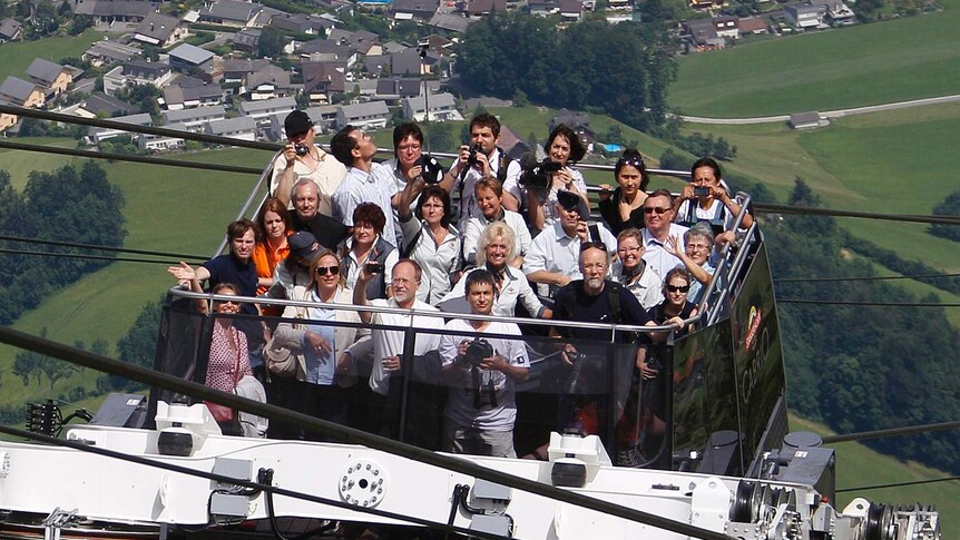 People ride on the world's first open-air double-decker cable car system.