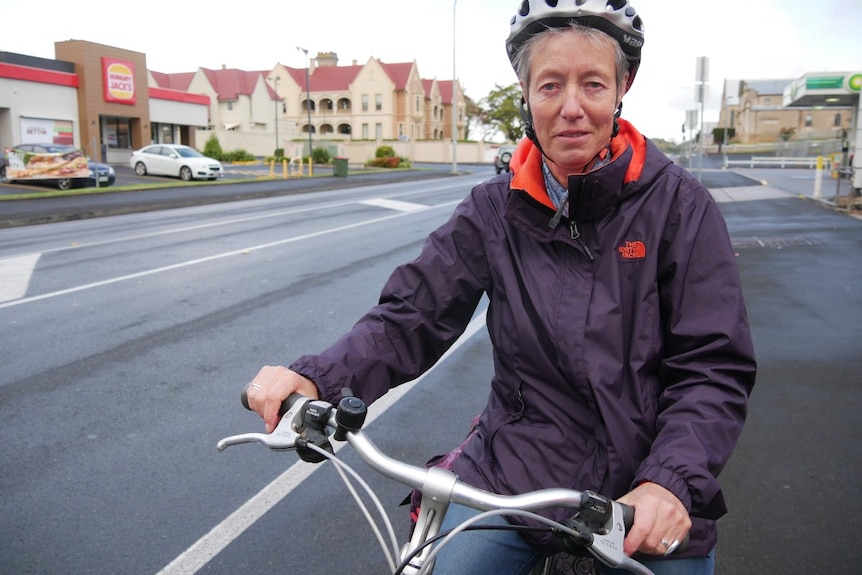 Woman with helmet on a bicycle in a street in Mount Gambier.