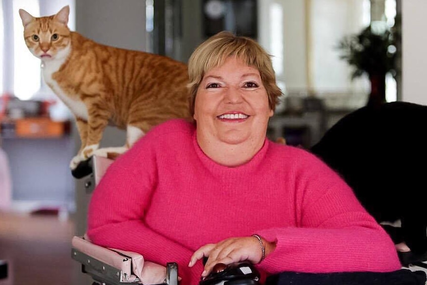 Ellie Robertson, who suffers from spinal muscular atrophy, with her two cats.
