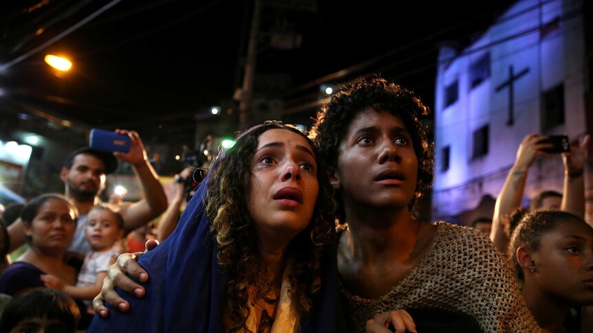 A man and woman portray mary and joseph watching on in the streets of rio de janeiro
