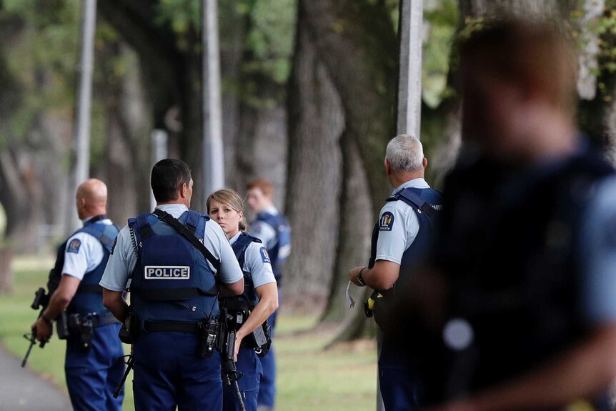 New Zealand police stand in a park after shootings at mosques in Christchurch.