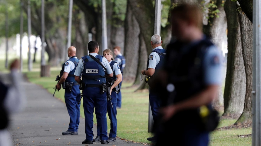 New Zealand police stand in a park after shootings at mosques in Christchurch.