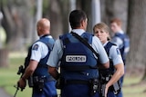 New Zealand police stand in a park after shootings at mosques in Christchurch.