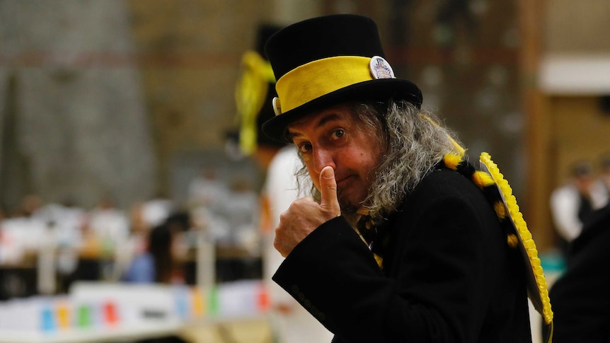 A member of the Monster Raving Loony party wears a yellow hat and