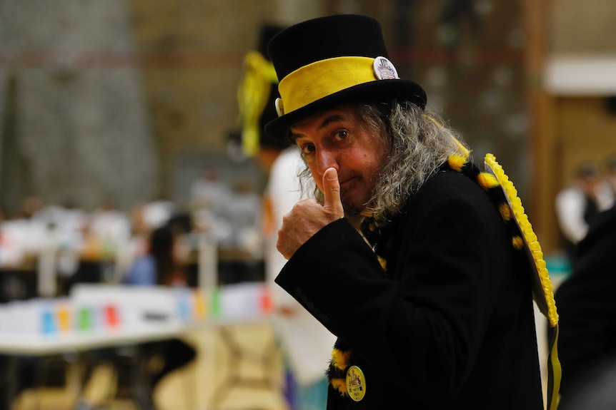 A member of the Monster Raving Loony party wears a yellow hat and