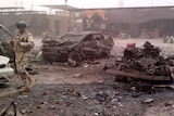 Iraq security personnel inspect the site of a car bomb attack at Jadidat al-Shatt.
