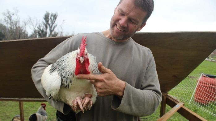 A man holds a chicken