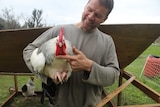 A man holds a chicken