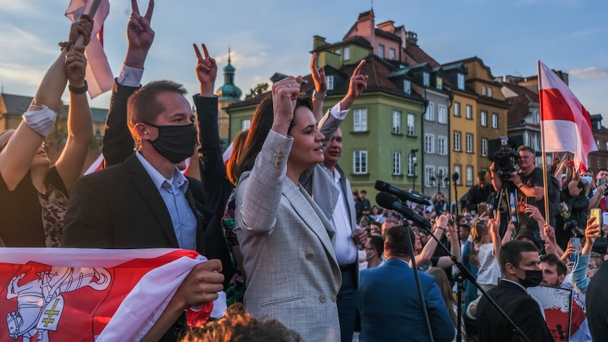 Belarus's exiled opposition leader holds up her fist during during a speech to a huge crowd in a speech in Poland