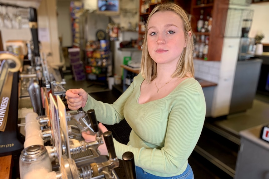 Ruby at the Melbourne pub she works at, pouring beers.