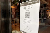 A QR code printed out on a page and stuck to a glass window