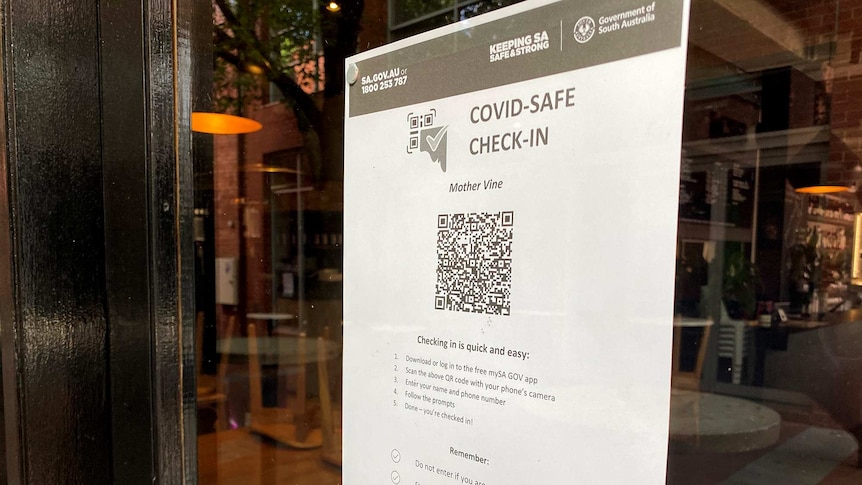 A QR code printed out on a page and stuck to a glass window