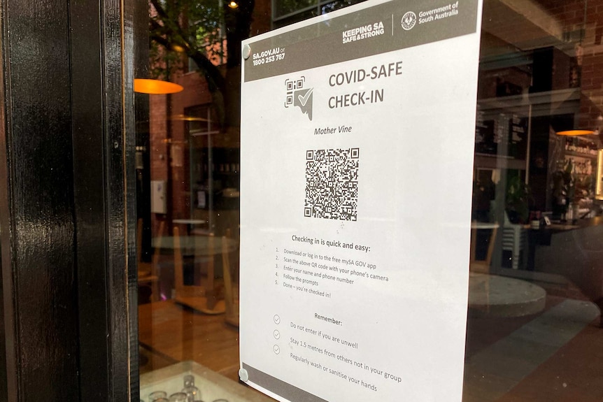 A QR code printed out on a page and stuck to a glass window