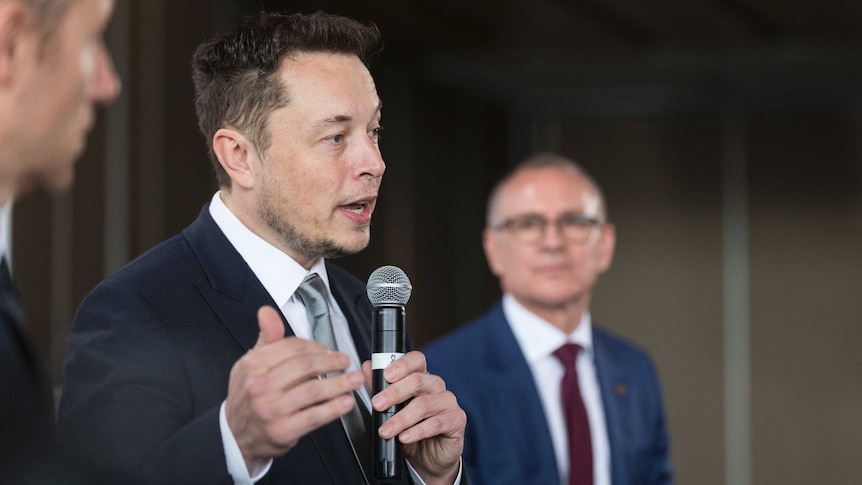 Jay Weatherill looks at Elon Musk while Musk talks about South Australia's energy.
