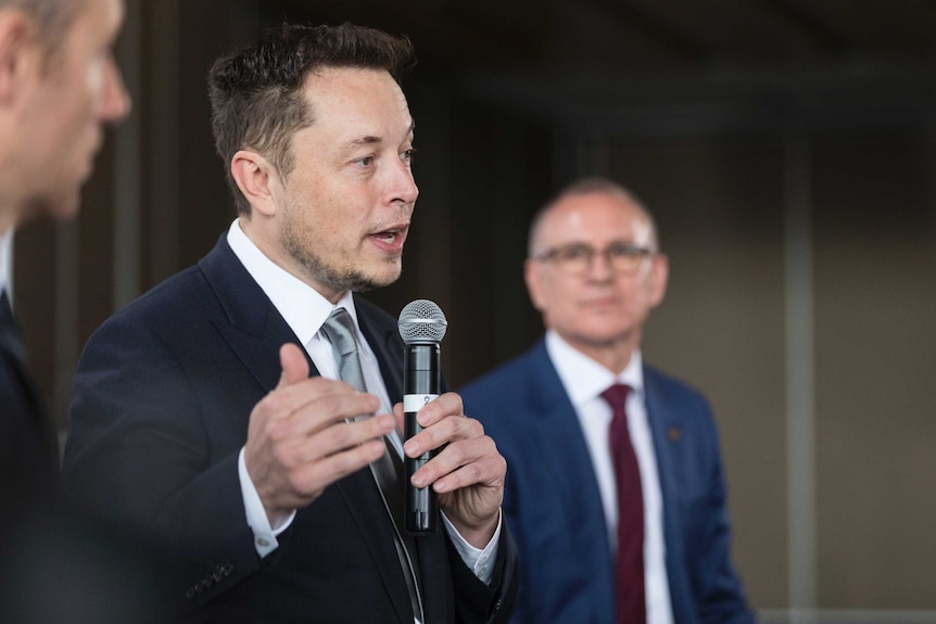 Jay Weatherill looks at Elon Musk while Musk talks about South Australia's energy.