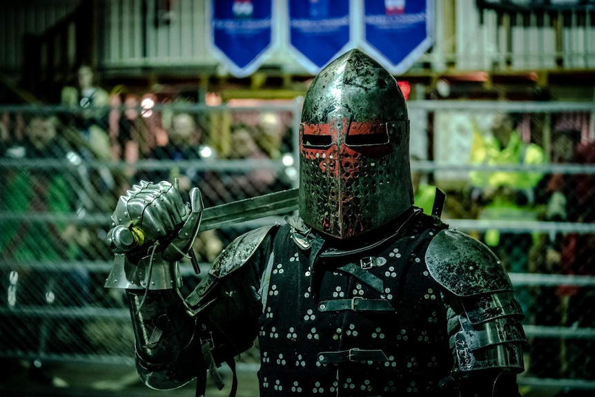 A fighter in armour holds a sword