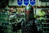 A fighter in armour holds a sword