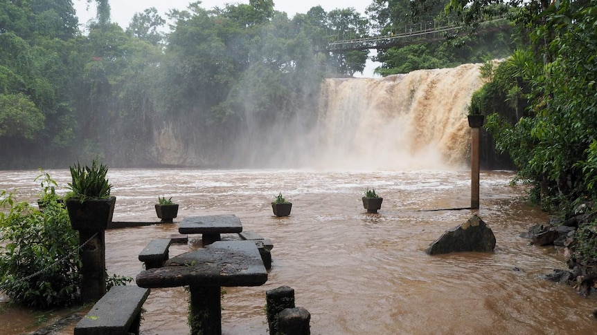 Mena Creek Falls flowing with a moderate amount of water.