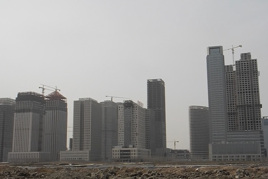 A row of tall apartment and office towers are under construction.
