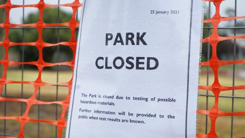 Printed sign on fence reading a park closure