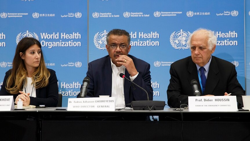 World Health Organisation member sitting on a panel with microphones in front of them.