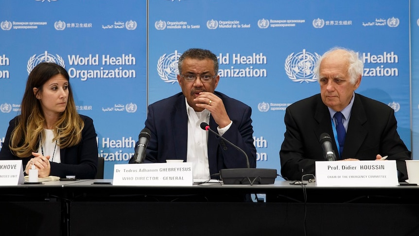 World Health Organisation member sitting on a panel with microphones in front of them.