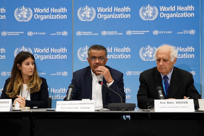 World Health Organisation member sitting on a panel with microphones in front of them.
