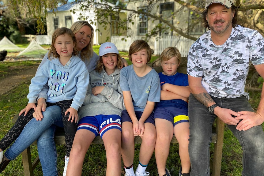 A family sit on a chair in country Victoria