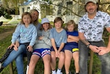 A family sit on a chair in country Victoria