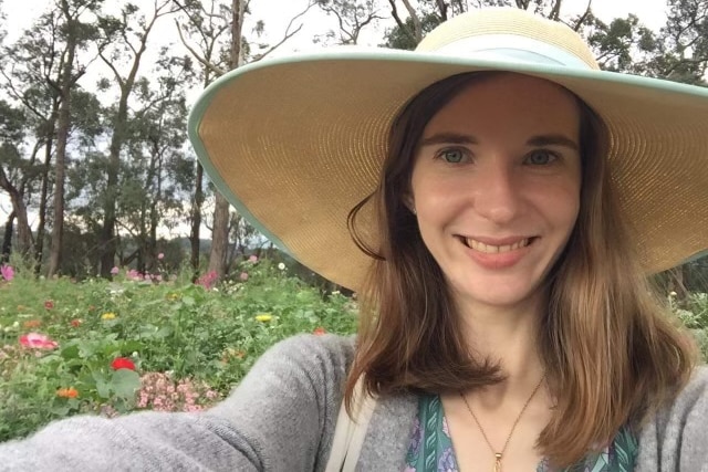 A selfie of Jessica Addley-Cook in front of flowers.