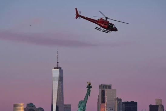 Helicopter in question flies by the statue of liberty.