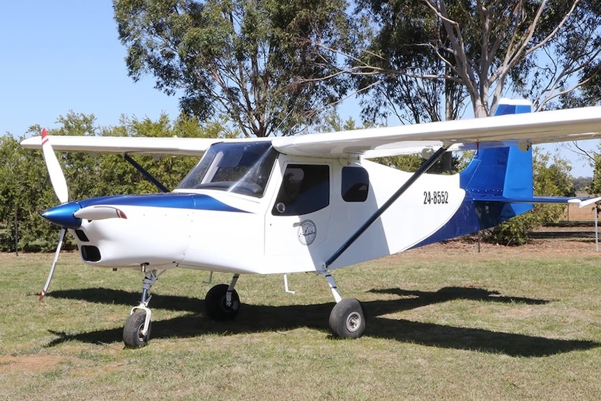 A Brumby 610 light plane parked on the ground. Trees are in the background.