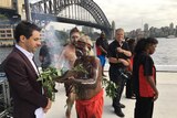 Aboriginal elder Uncle Max Eulo leads a smoking ceremony and holds the leaves in front of John Foreman in Circular Quay.