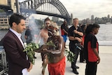 Aboriginal elder Uncle Max Eulo leads a smoking ceremony and holds the leaves in front of John Foreman in Circular Quay.