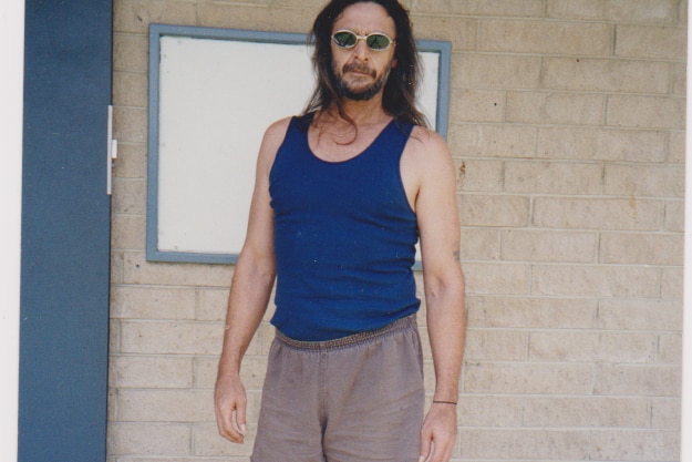 An Indigenous man with long hair in a blue singlet in prison in the 90s.