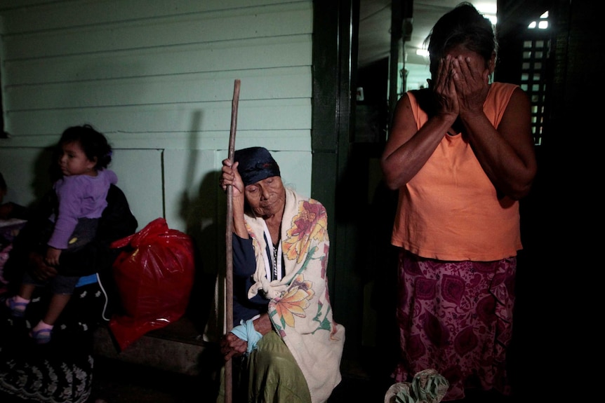 Women sit an wait at evacuation centre