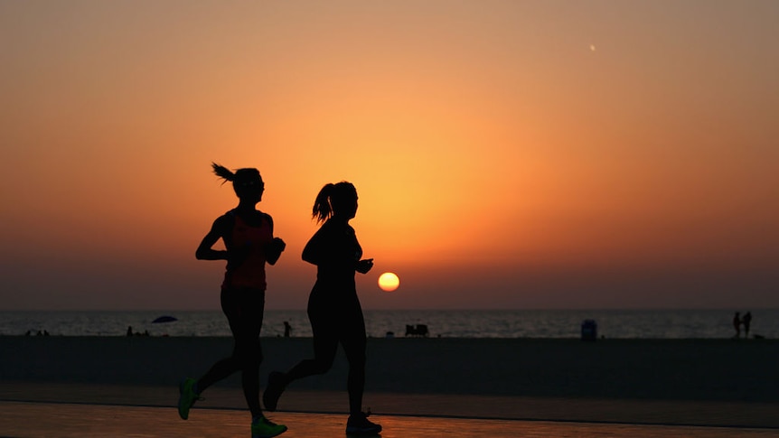 Two women jogging along a beach