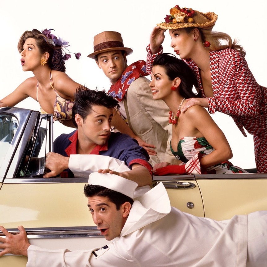 A1950s style photo shoot of the cast of friends driving in a car.