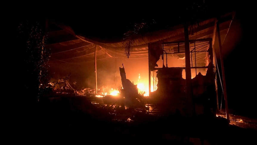 Flames shown inside a structure at night