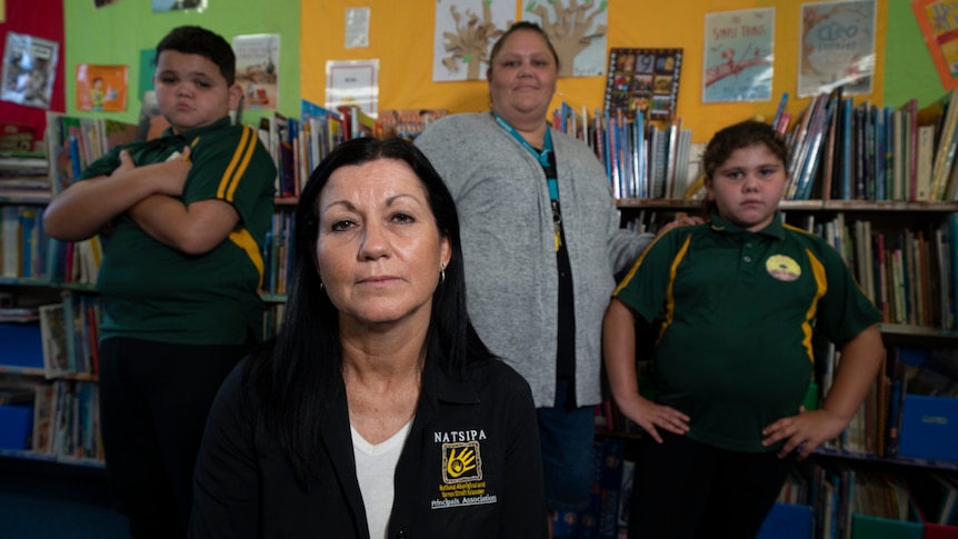 Two adult women and two children in school uniform looking annoyed.