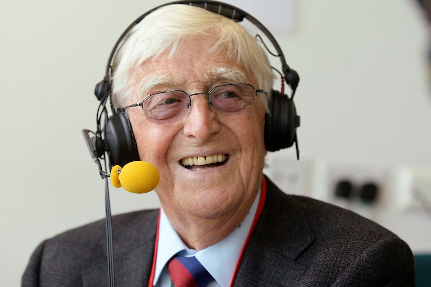 Sir Michael Parkinson wearing a headset. 