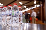 A close-up shot of bottles of water on a table.