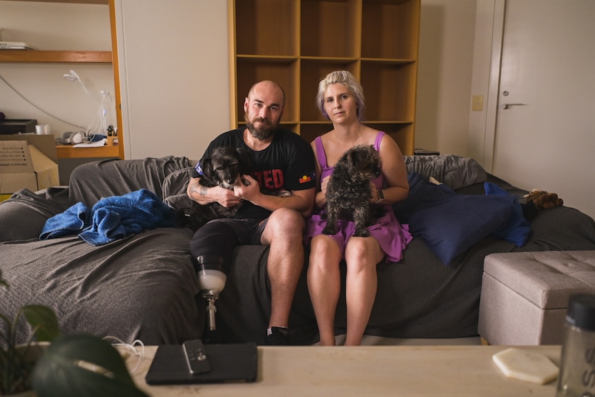 Katie Havelberg mit Dale Billett und seinem amputierten Bein sichtbar, während sie auf der Couch sitzen.