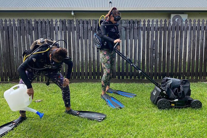 Passions of Paradise reef tour employees dress in scuba gear on the grass in a backyard