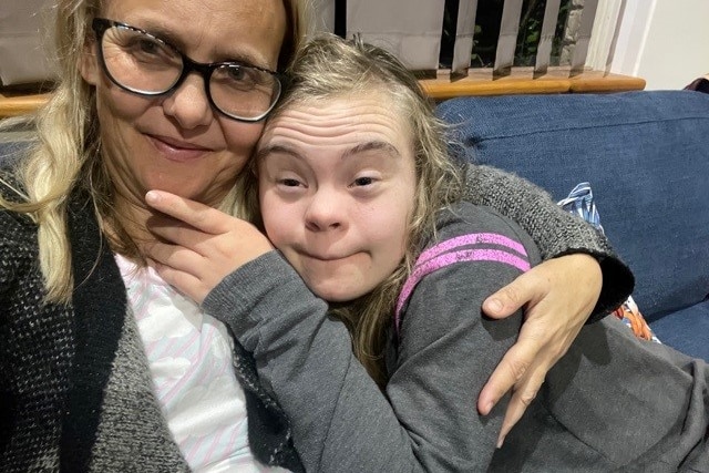 Tarryn and Isla hugging on the couch