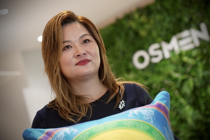 Michelle Lam is brand director for outdoor furniture store Osmen, holding a cushion.